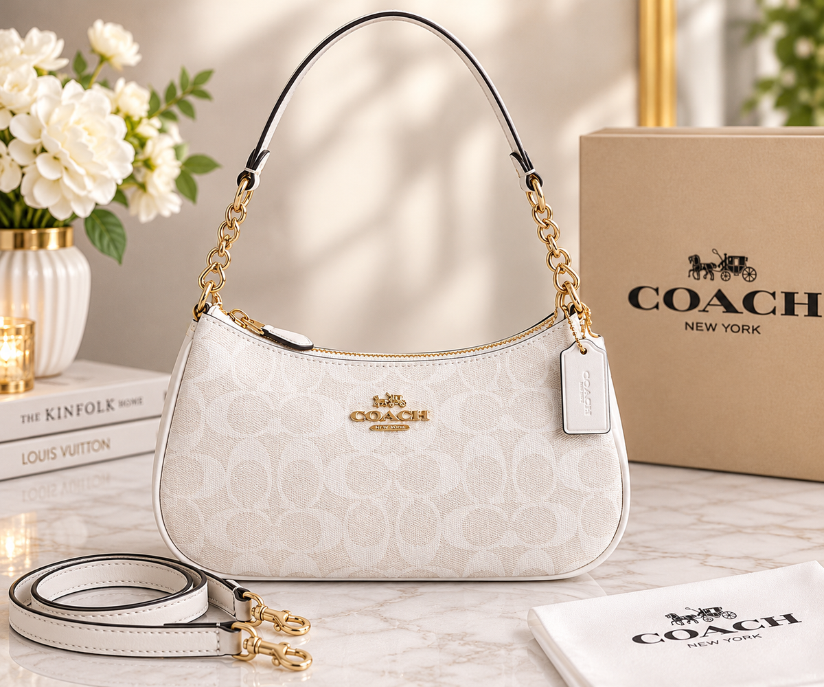 White Coach signature-style shoulder bag with gold-tone chain-detail shoulder strap, detachable long strap, zipper closure, and logo tag.