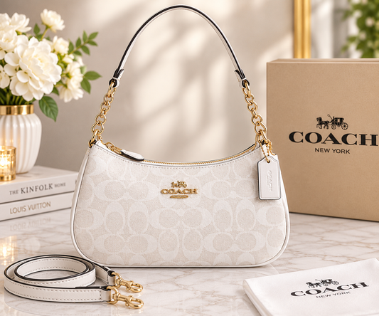 White Coach signature-style shoulder bag with gold-tone chain-detail shoulder strap, detachable long strap, zipper closure, and logo tag.