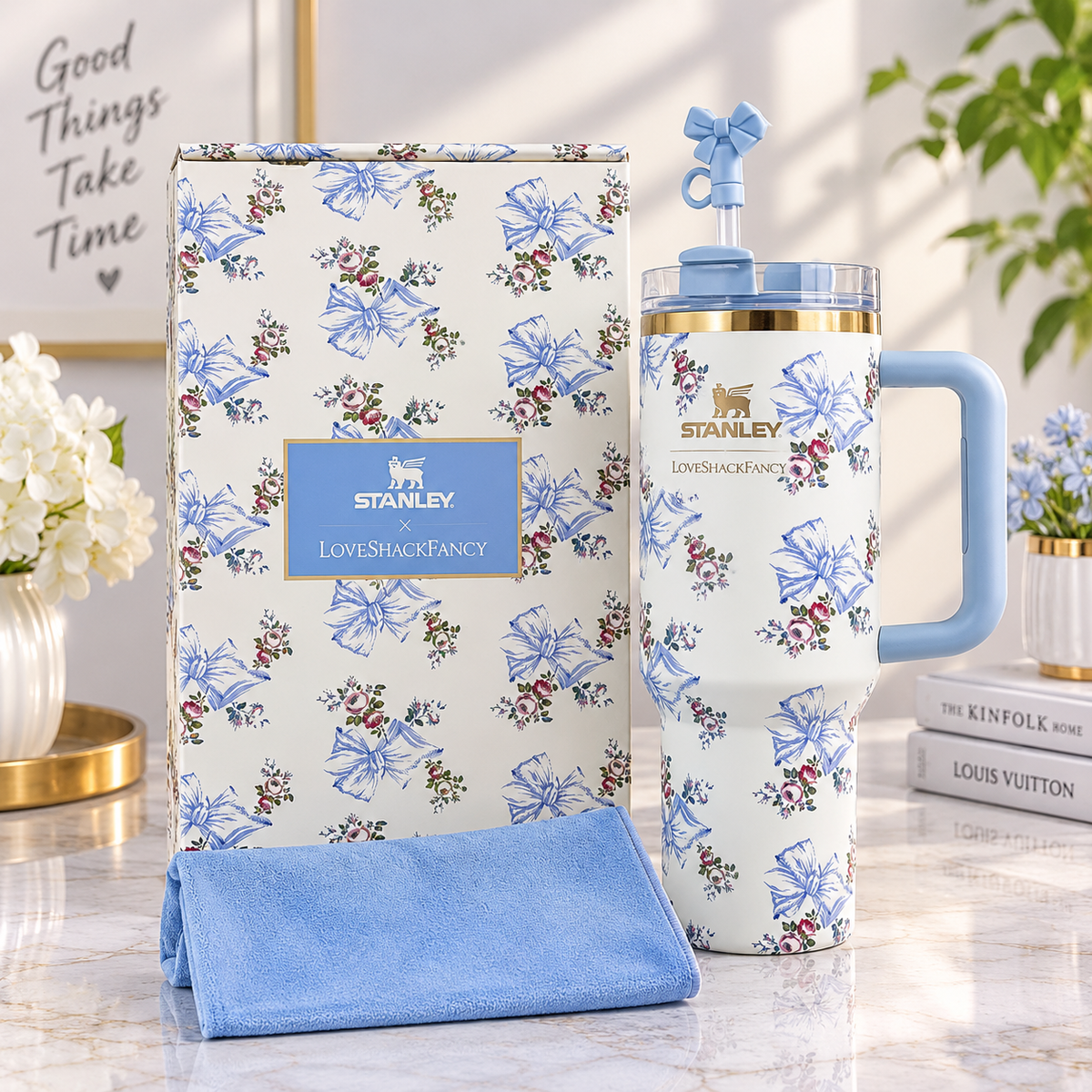 White tumbler with blue bow and floral print, blue side handle, matching straw, and coordinating floral gift box.