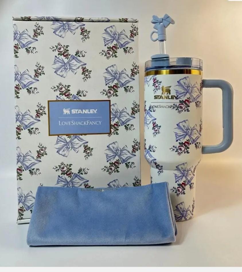 White tumbler with blue bow and floral print, blue side handle, matching straw, and coordinating floral gift box.